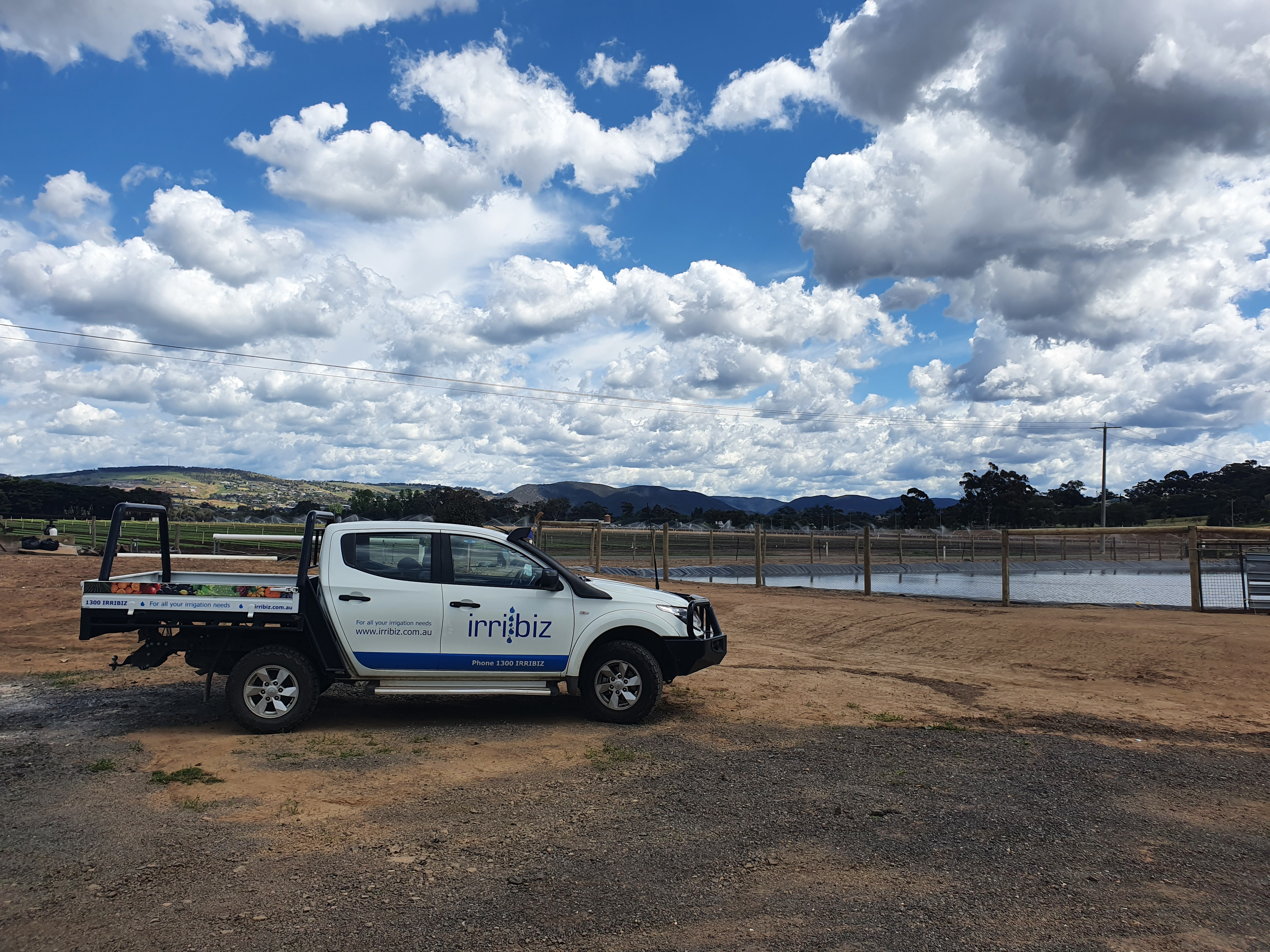 Irribiz ute in a field and a dam in the background